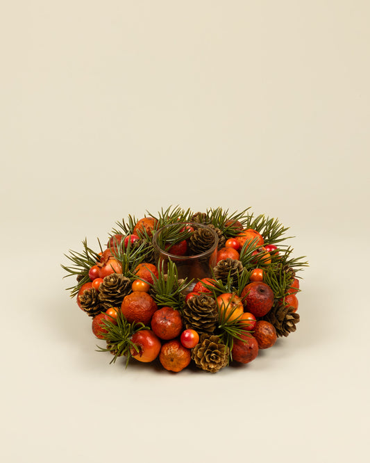 Centrotavola autunnale con portacandela, bacche e pigne