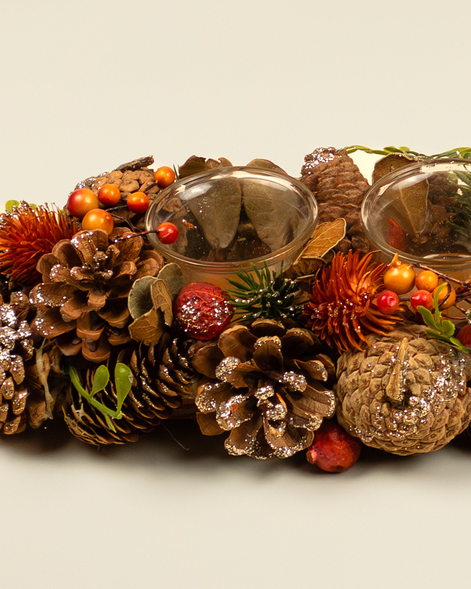 Centrotavola autunnale con portacandele, pigne e bacche