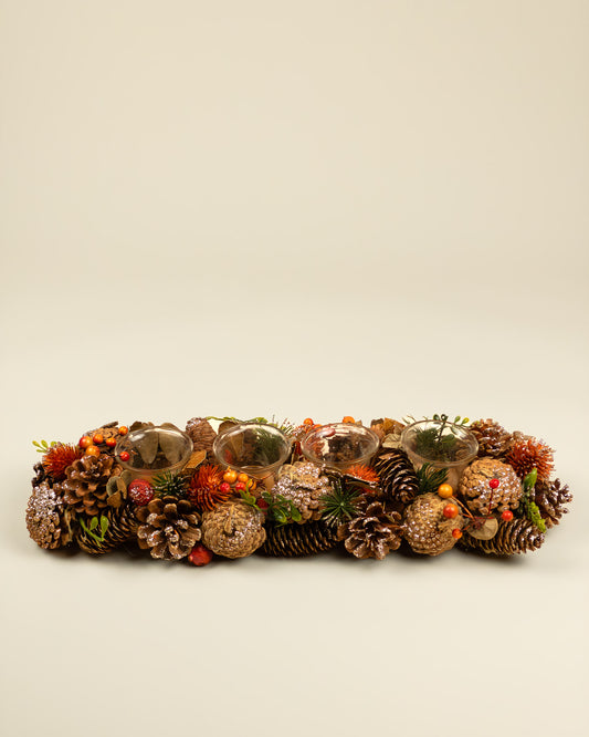 Centrotavola autunnale con portacandele, pigne e bacche