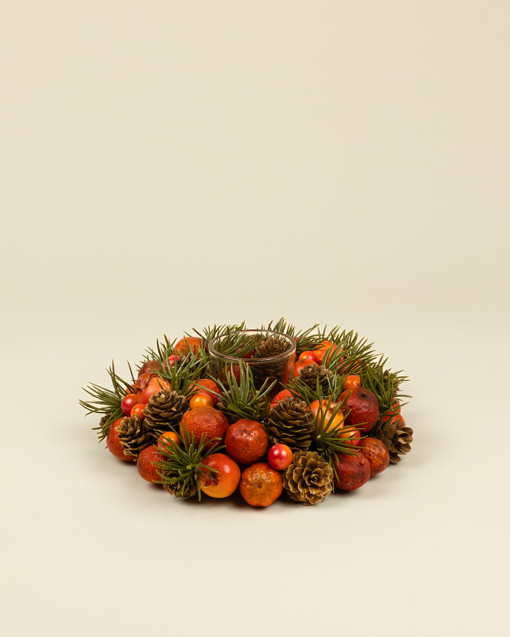 Centrotavola autunnale con portacandela, bacche e pigne