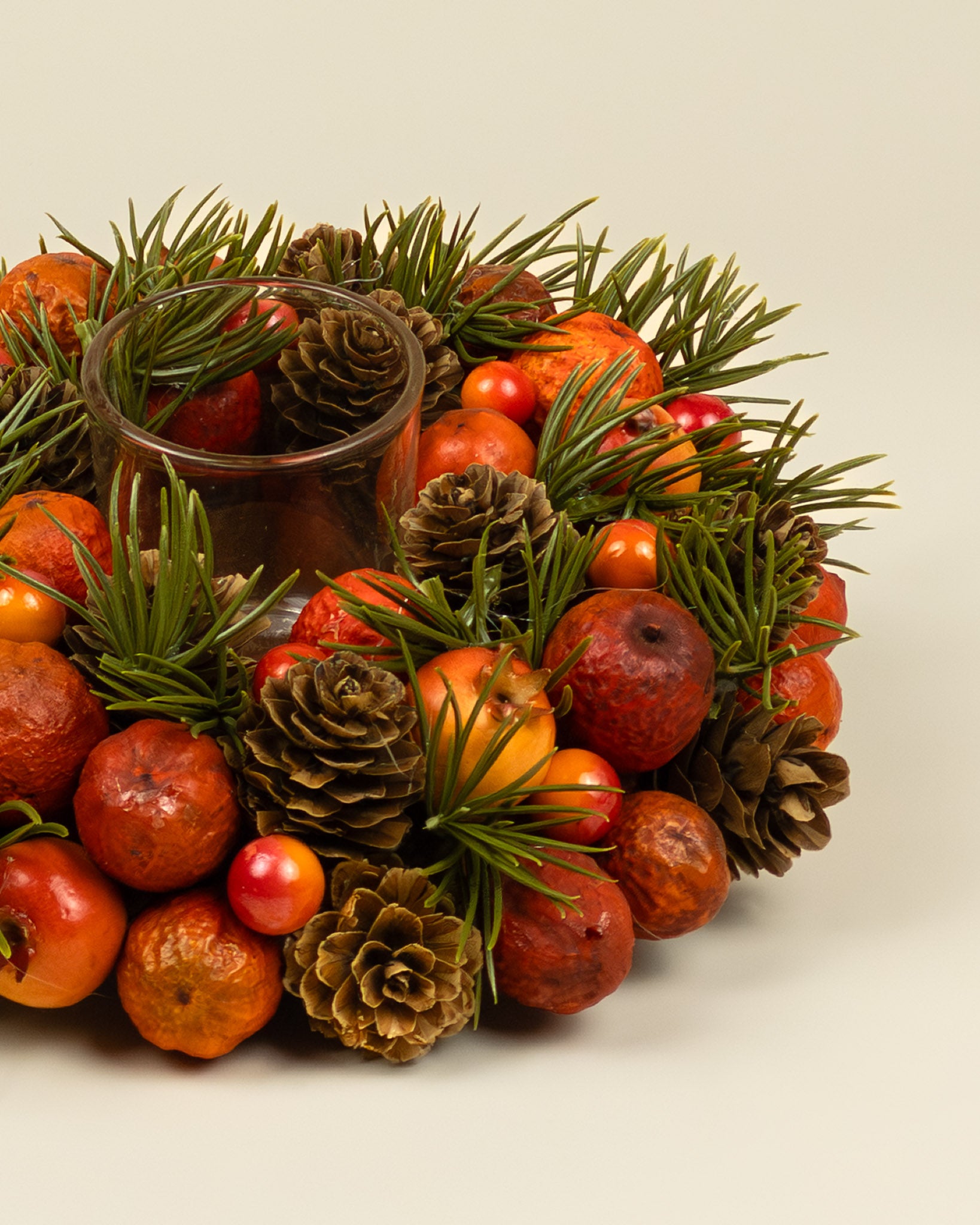 Centrotavola autunnale con portacandela, bacche e pigne